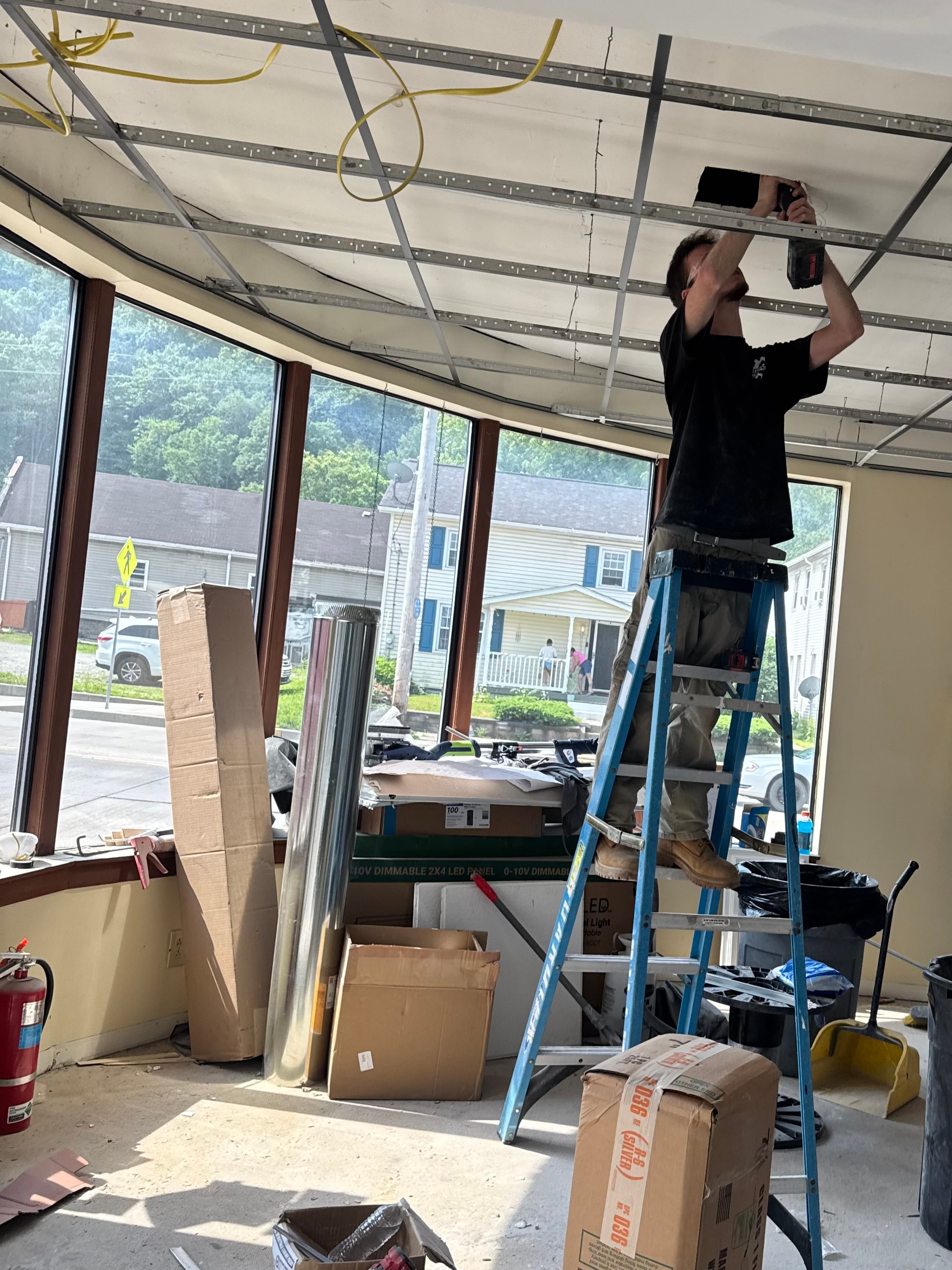 Heirloom Mechanical technician installing ceiling ductwork and diffuser in commercial space near Pittsburgh, PA