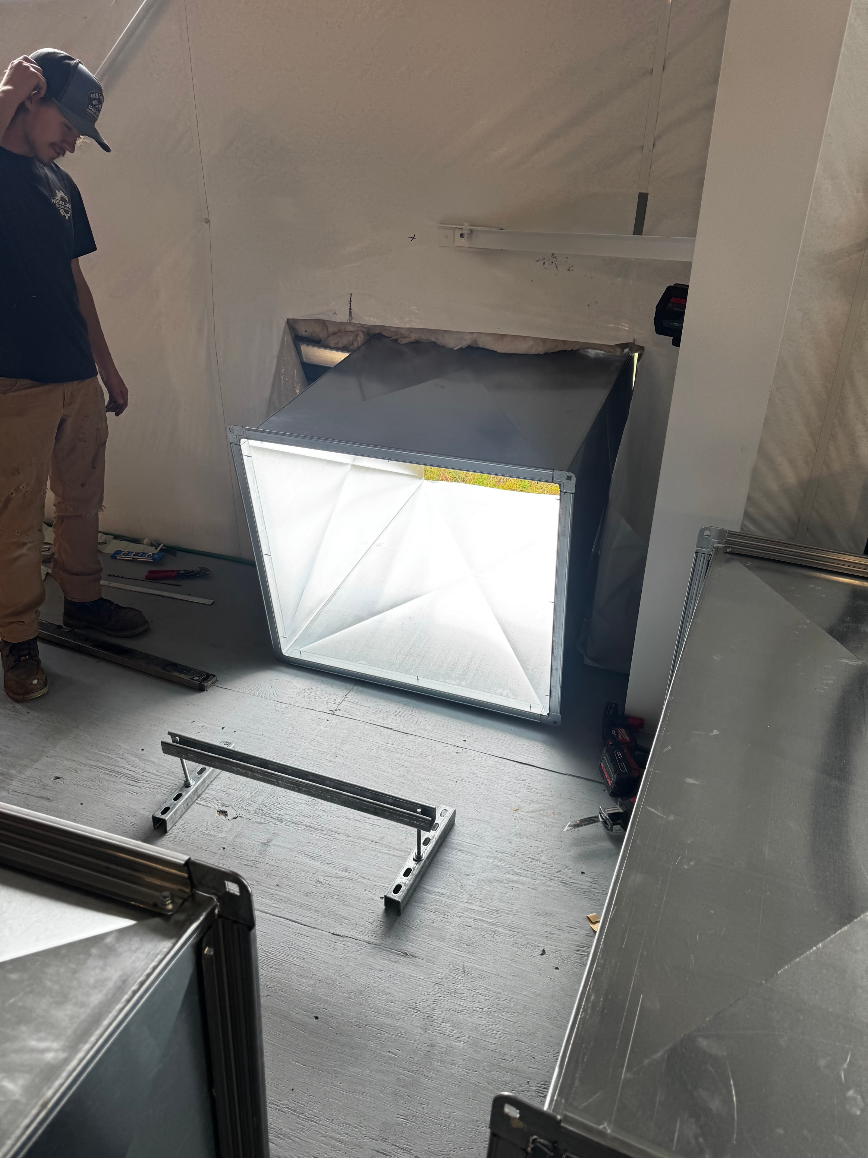 Heirloom Mechanical technician fitting a custom sheet metal plenum box during commercial ductwork installation in Monroeville, PA